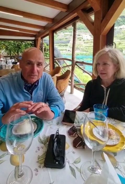 Una pareja de clientes conversa bajo las vigas de madera de un restaurante