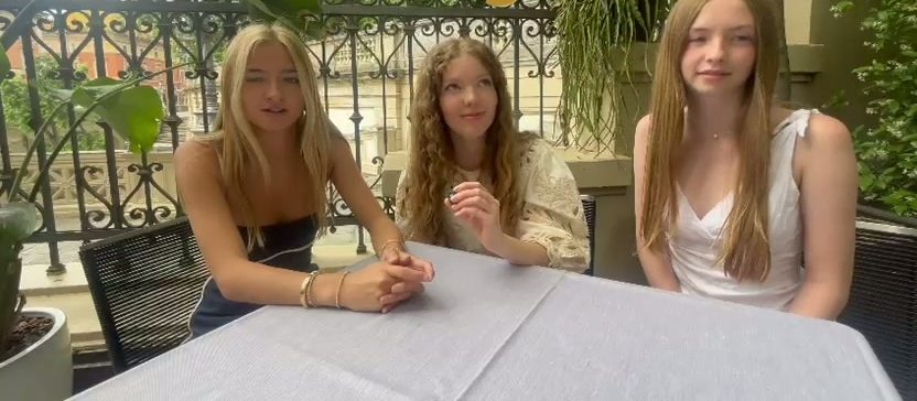 Tres clientes sentados juntos a una mesa en una terraza al aire libre