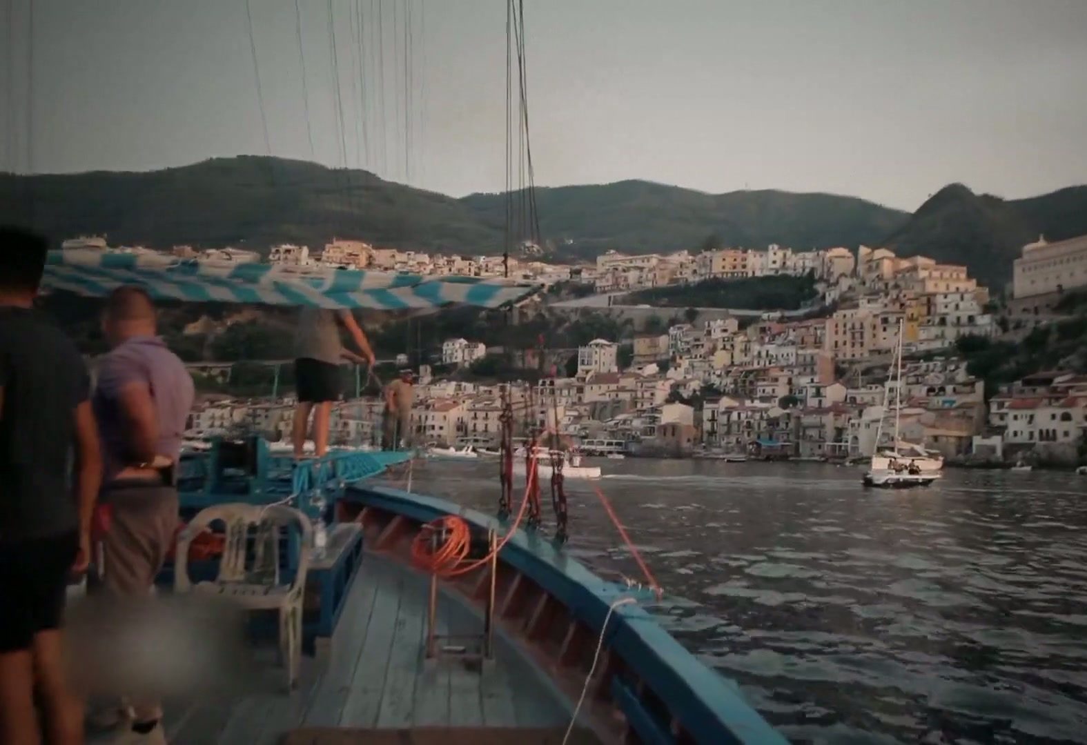 View from a traditional fishing boat toward a coastal town on the Strait of Messina