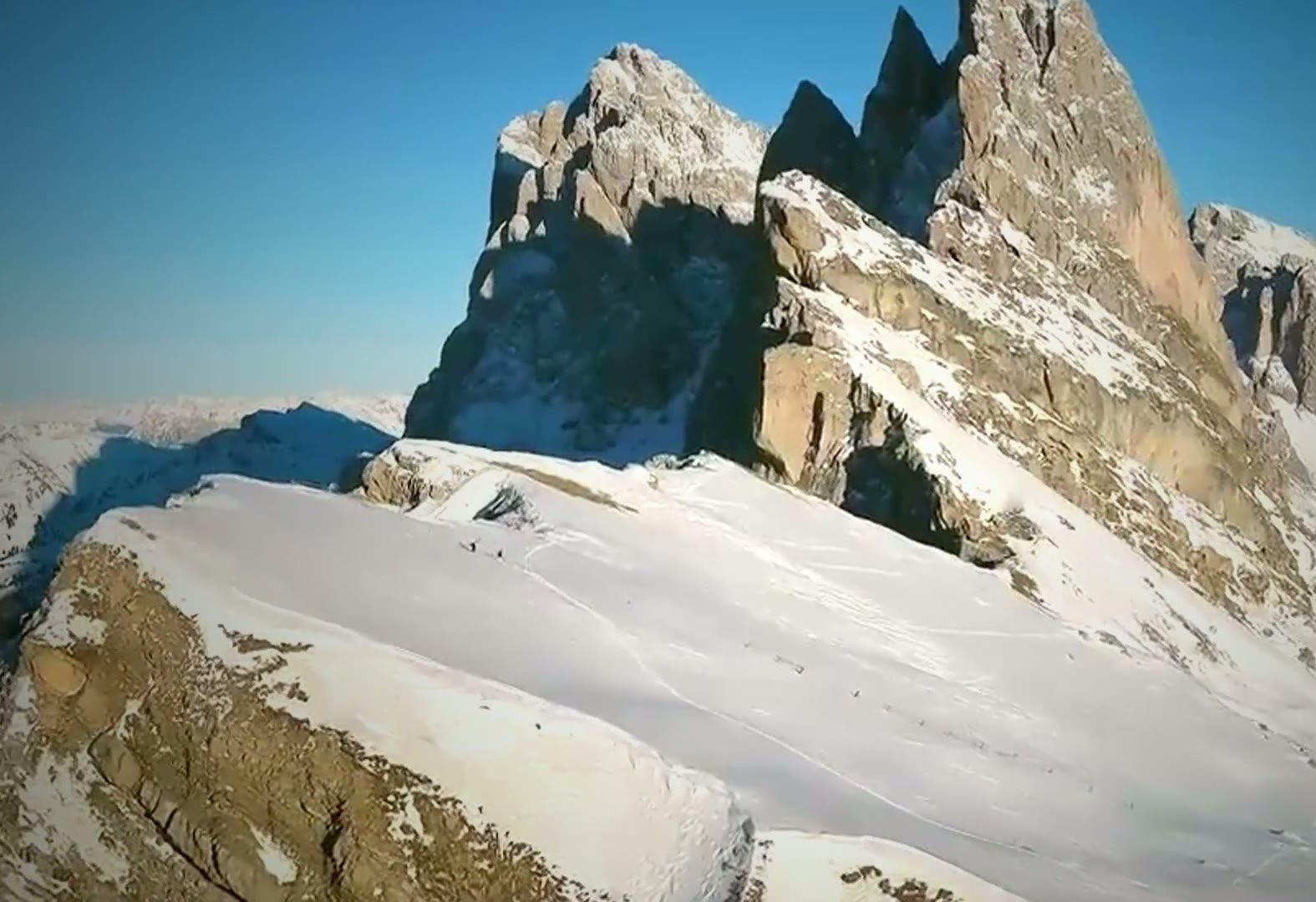 Cumbres nevadas de los Dolomitas que se elevan sobre un glaciar bajo un cielo azul despejado