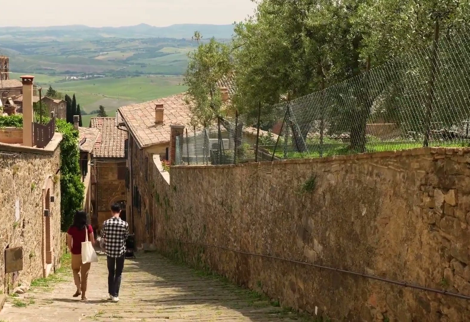 Stone lane in Montalcino opening onto the Val d'Orcia hills